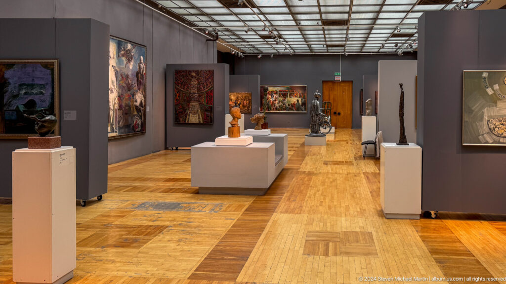 Wide modern museum gallery with sculpture plinths.