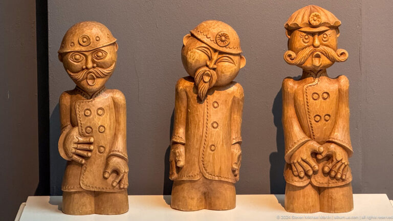 Three carved wooden male figures.
