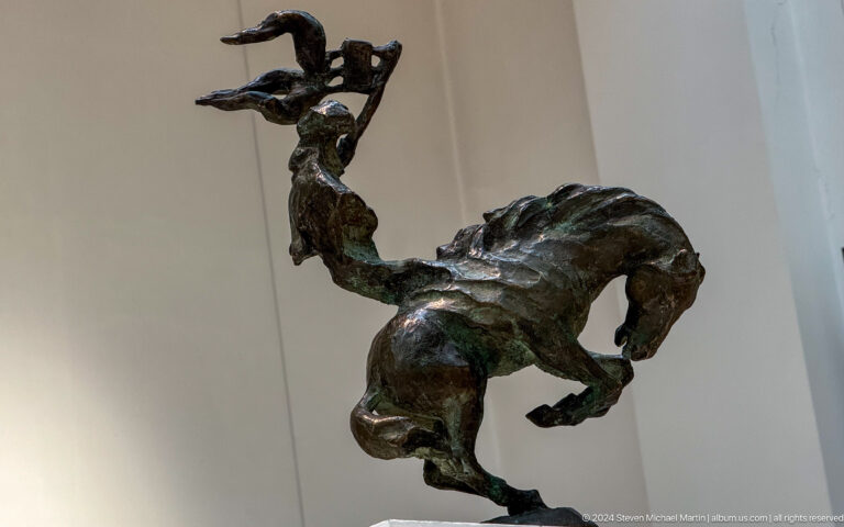 Dark rider or acrobat with raised arm.