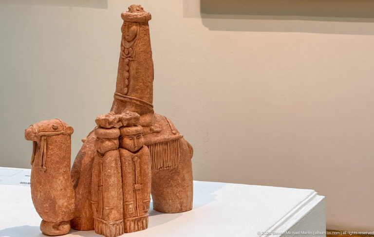 Terracotta group of vessels and upright forms.