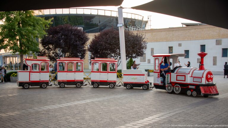 Red-and-white miniature tourist train with open-sided coaches at Kok Tobe recreation area.