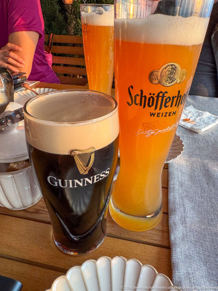 A glass of Guinness and a glass of Schöfferhofer wheat beer on a restaurant table.