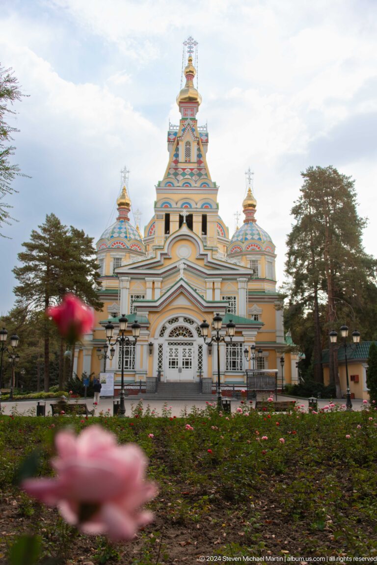 Frontal view with rose in foreground at the colorful wooden Zenkov Cathedral in Almaty.