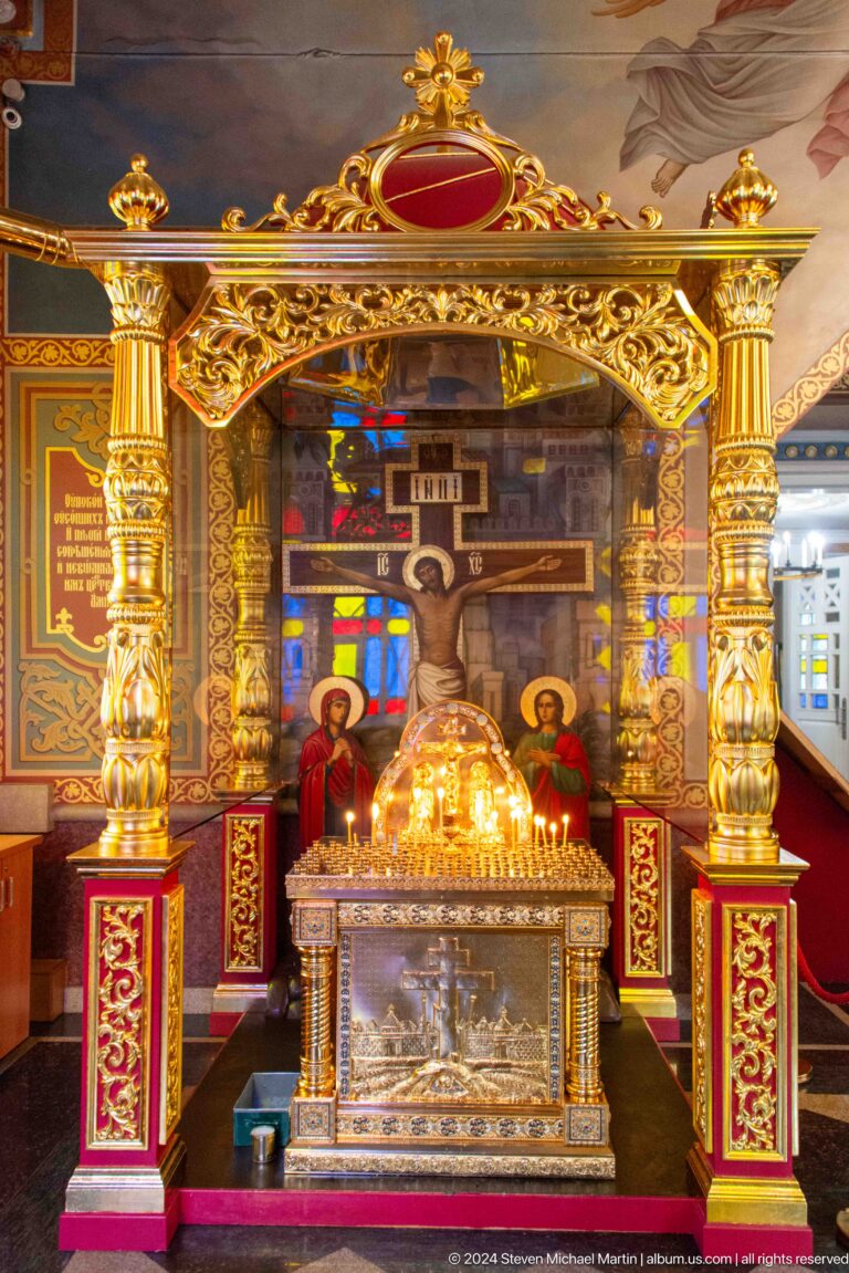 Gilded crucifix shrine with icons inside Zenkov Cathedral, with Orthodox religious decoration.