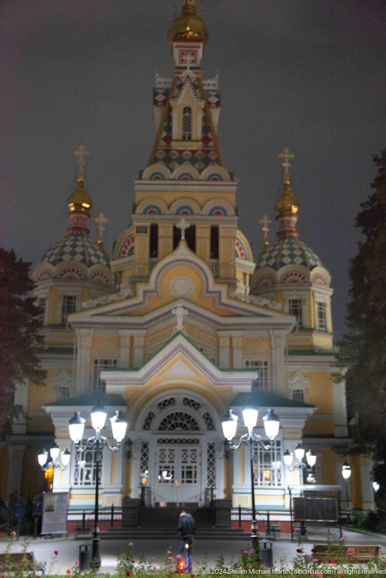 Illuminated central facade and domes at the colorful wooden Zenkov Cathedral in Almaty.