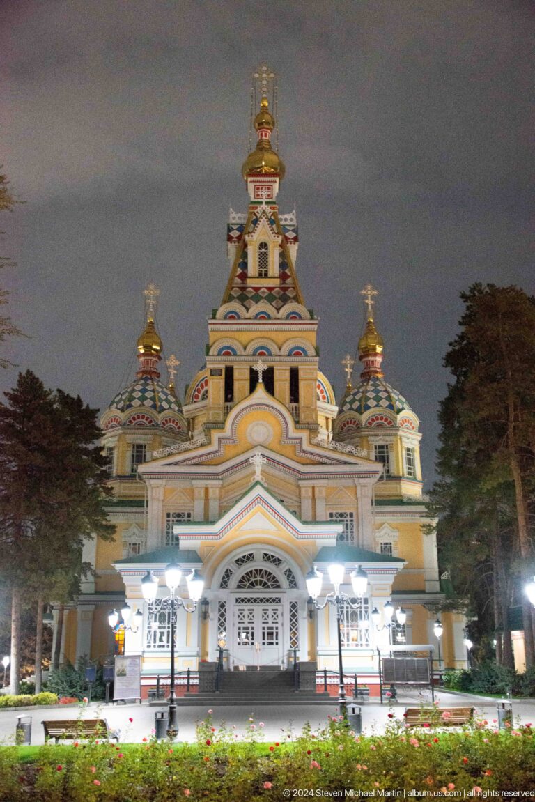 Closer night view of central tower and domes at the colorful wooden Zenkov Cathedral in Almaty.