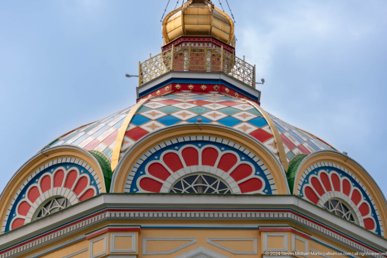 Close exterior dome with patterned roof at the colorful wooden Zenkov Cathedral in Almaty.