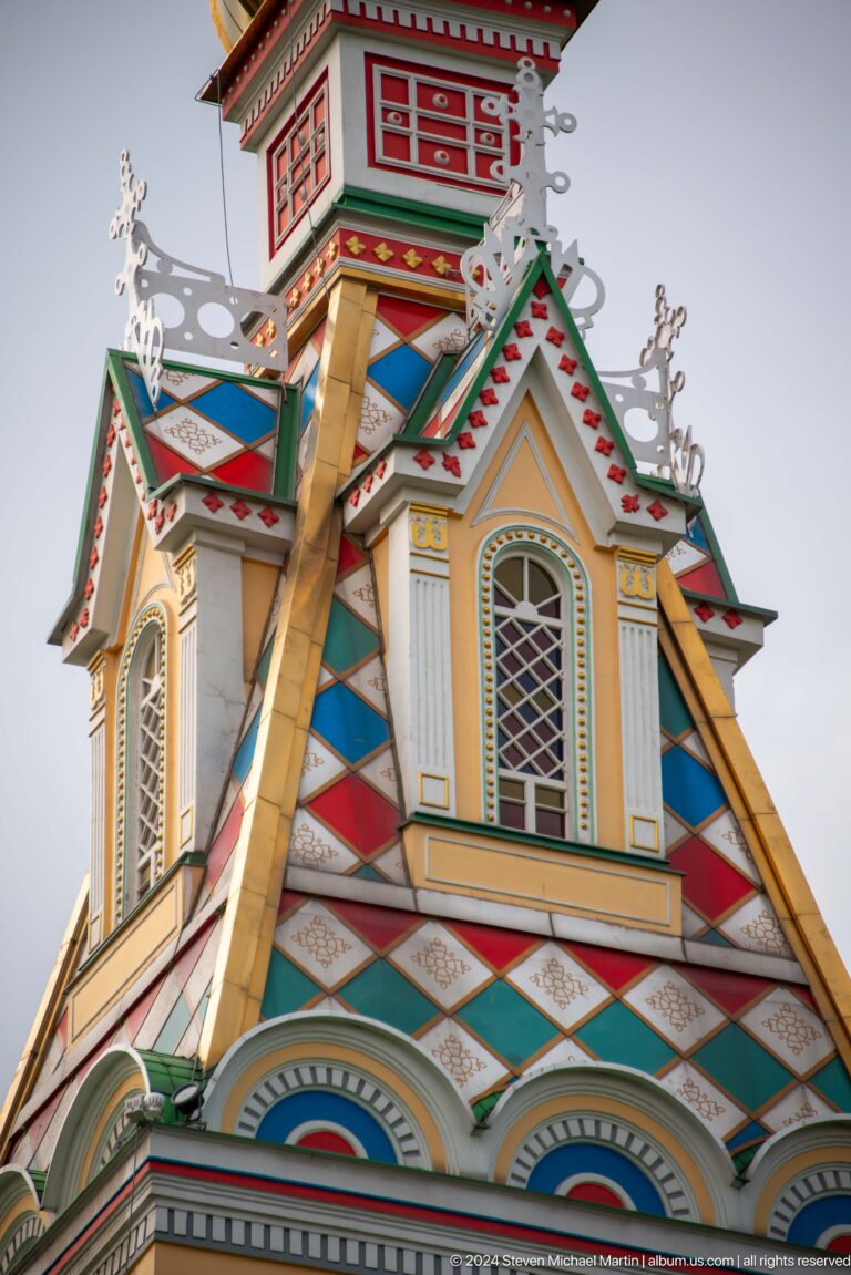 Painted tower detail with lancet window at the colorful wooden Zenkov Cathedral in Almaty.