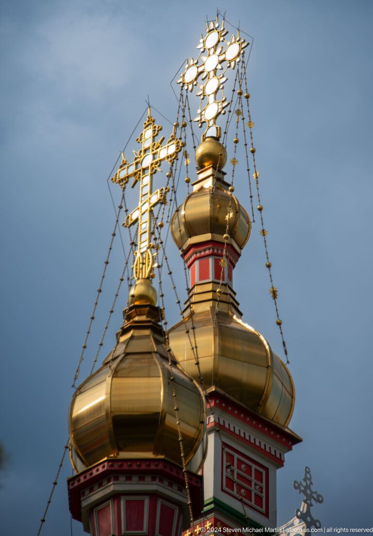 Golden onion domes with crosses at the colorful wooden Zenkov Cathedral in Almaty.