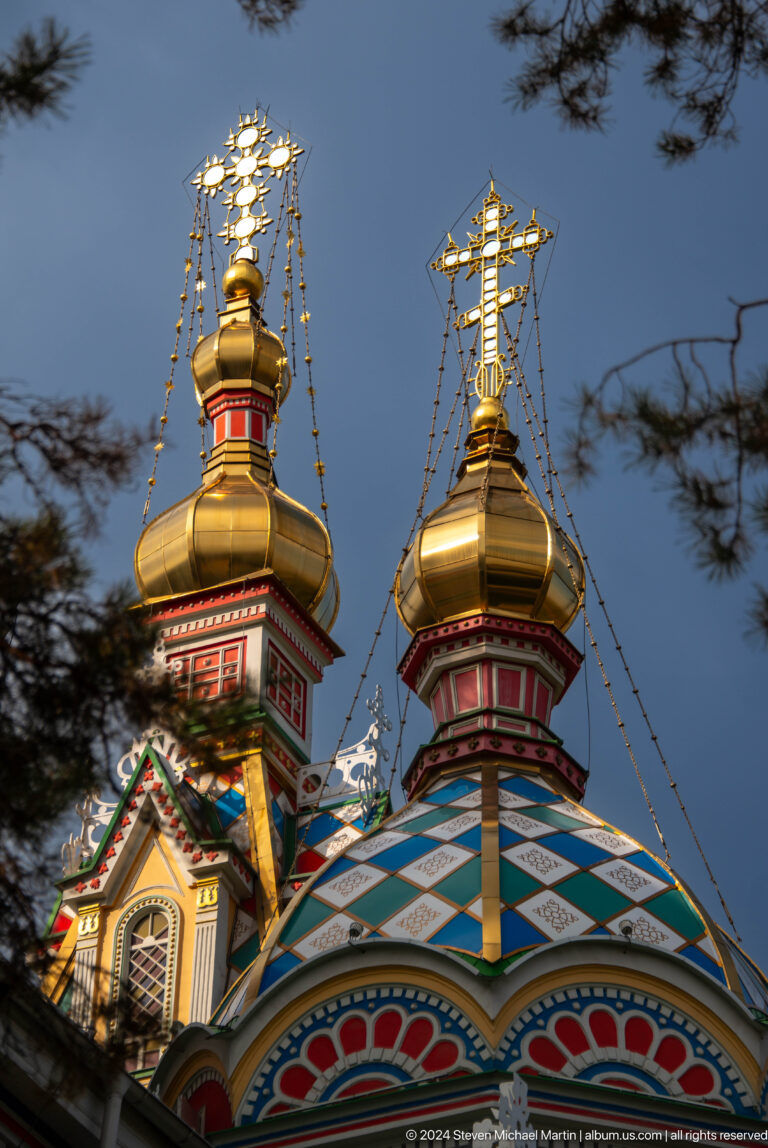 Paired golden onion domes at the colorful wooden Zenkov Cathedral in Almaty.