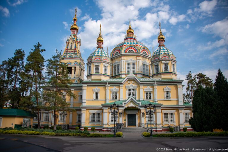 Wide symmetrical daytime front view at the colorful wooden Zenkov Cathedral in Almaty.