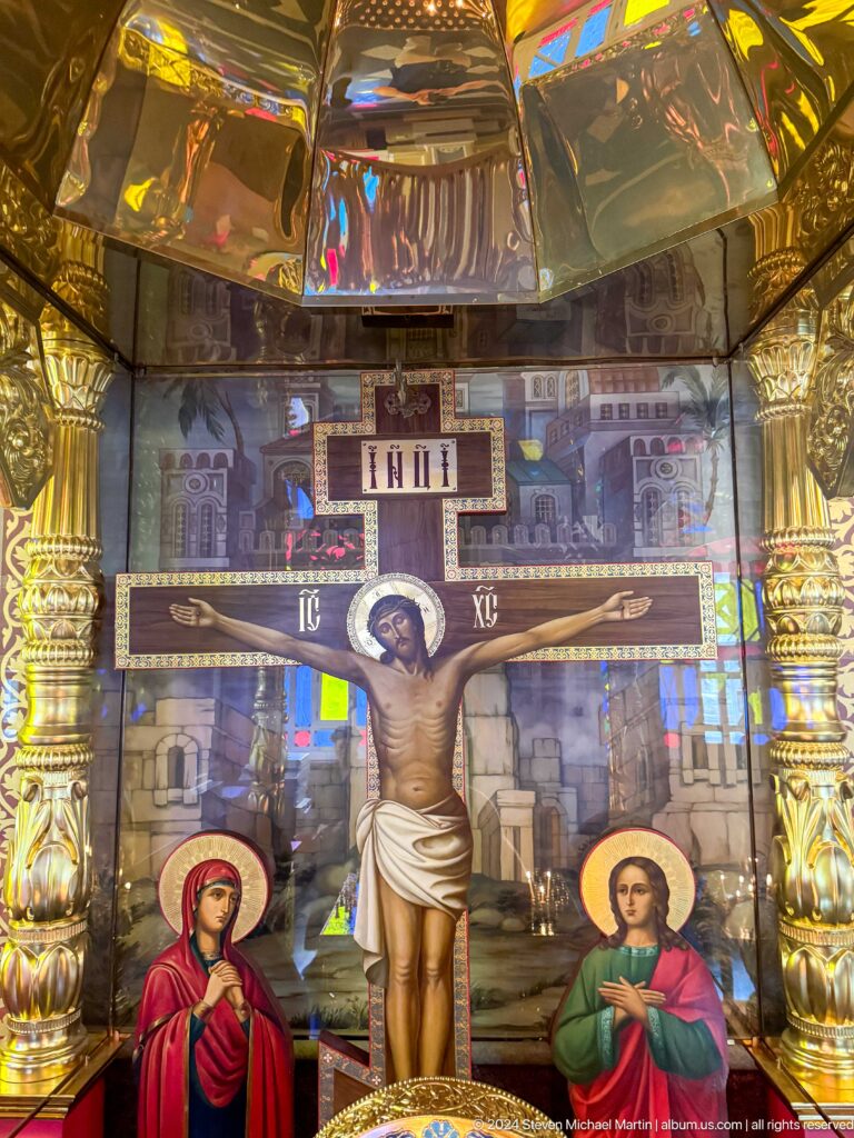 Close crucifix with INRI inscription inside Zenkov Cathedral, with Orthodox religious decoration.