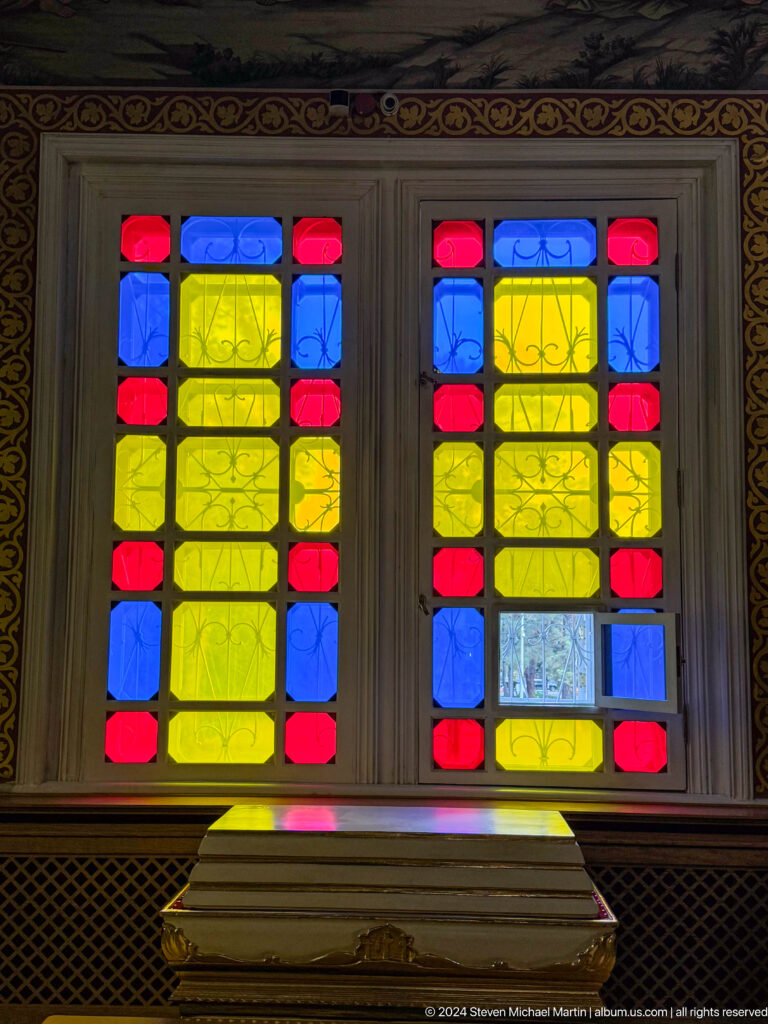 Geometric stained-glass window inside Zenkov Cathedral, with Orthodox religious decoration.