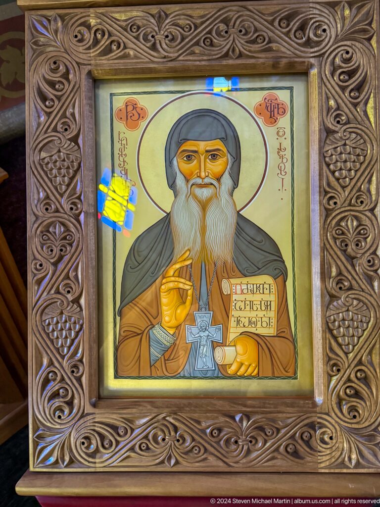 Painted saint holding a scroll inside Zenkov Cathedral, with Orthodox religious decoration.