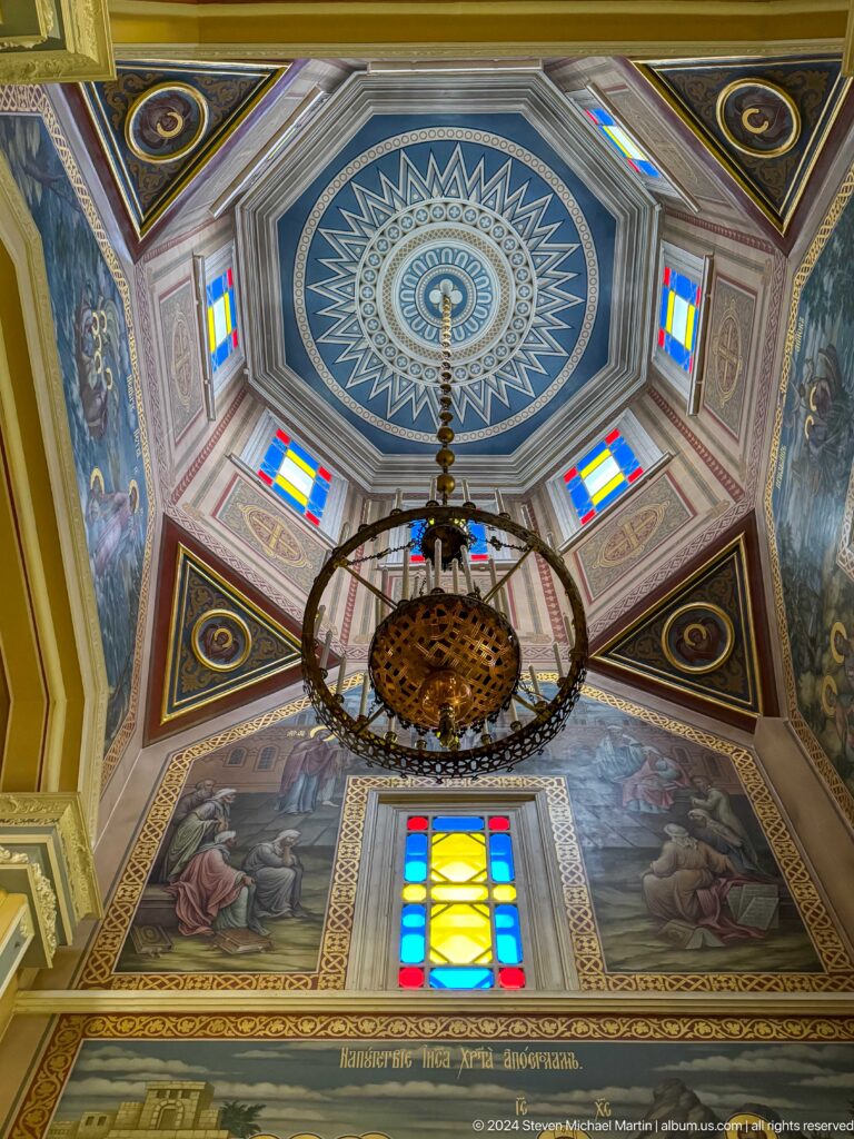 Dome ceiling and hanging chandelier at the colorful wooden Zenkov Cathedral in Almaty.