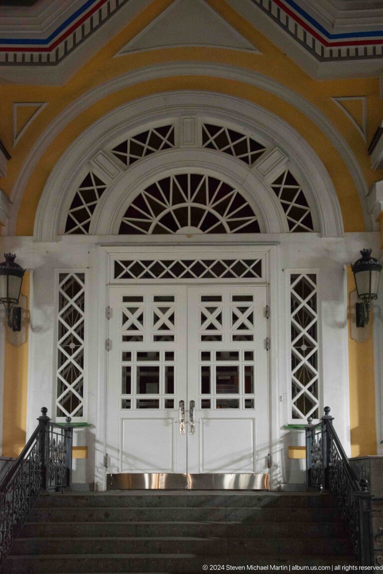 Close view of white lattice doors and fanlight at the colorful wooden Zenkov Cathedral in Almaty.