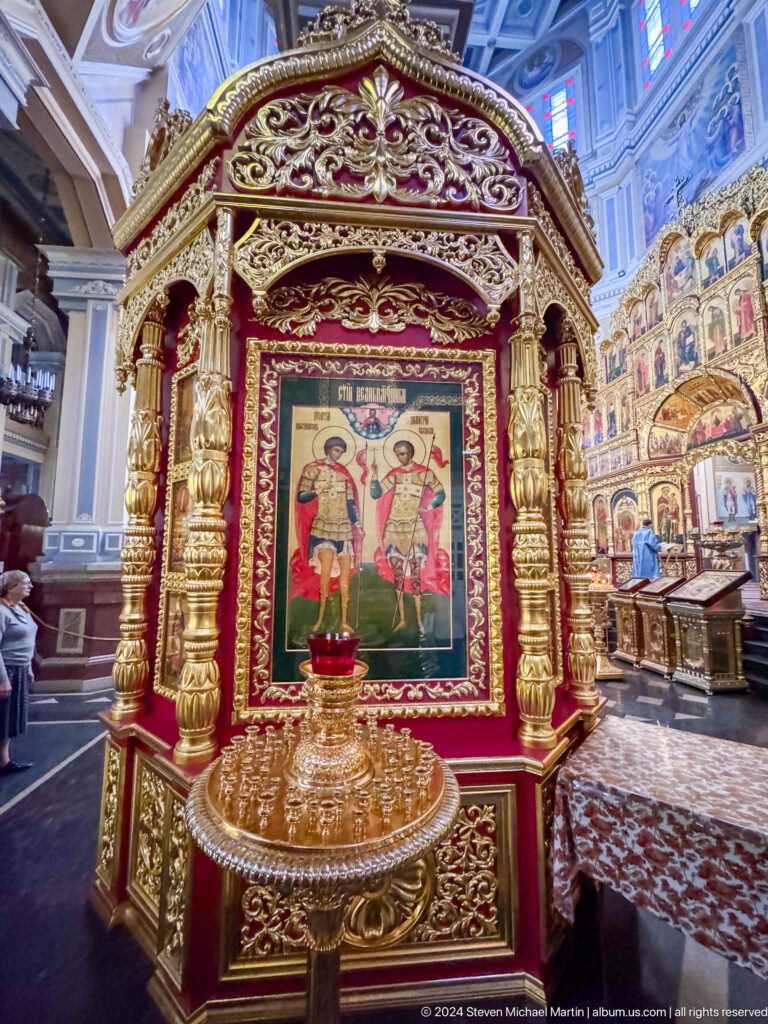 Gilded framed icon in side chapel inside Zenkov Cathedral, with Orthodox religious decoration.
