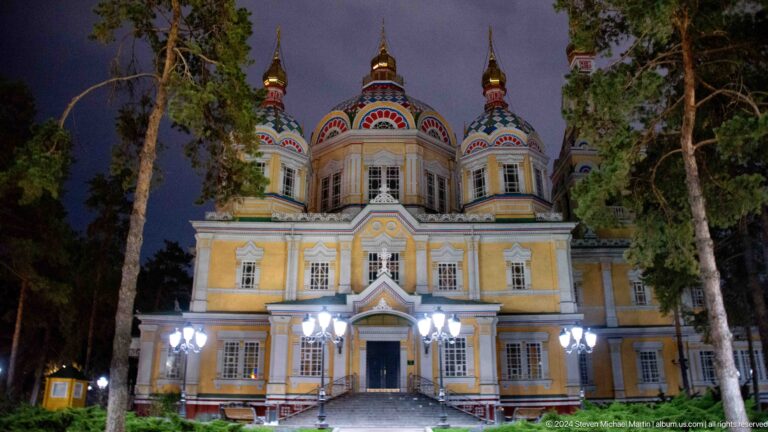 Night side elevation with multiple domes at the colorful wooden Zenkov Cathedral in Almaty.