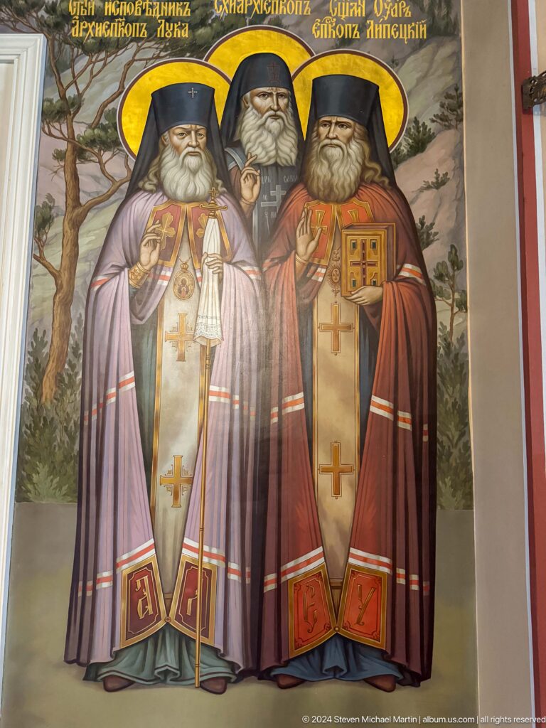 Two standing bishops or saints inside Zenkov Cathedral, with Orthodox religious decoration.
