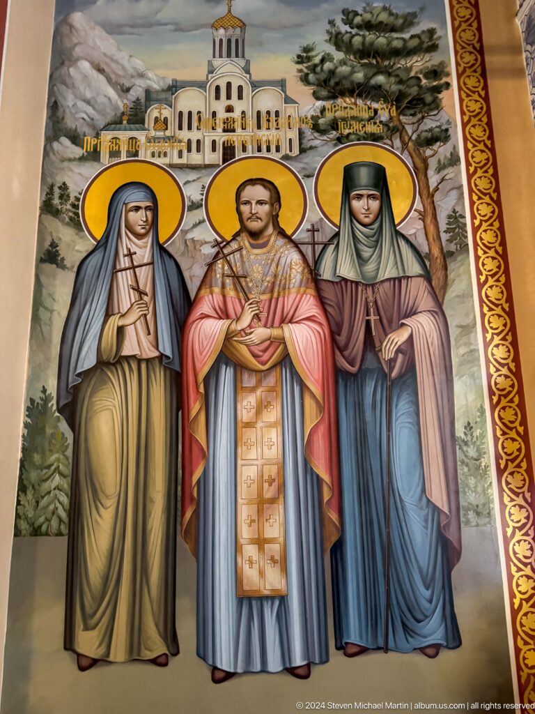 Three standing female saints inside Zenkov Cathedral, with Orthodox religious decoration.