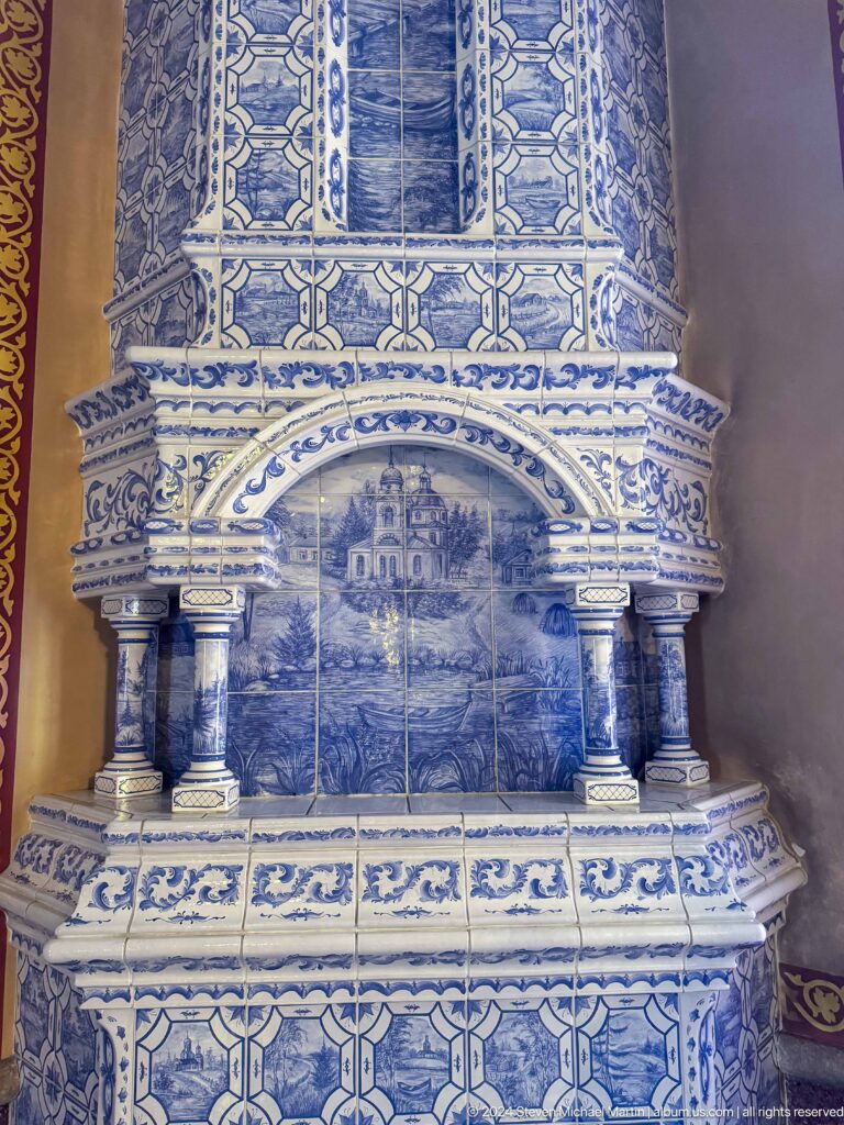 Blue-and-white tiled memorial structure inside Zenkov Cathedral, with Orthodox religious decoration.