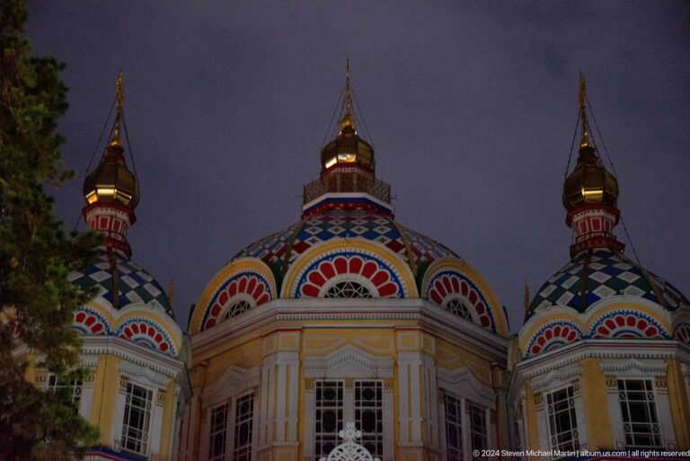 Upper apse and domes at dusk at the colorful wooden Zenkov Cathedral in Almaty.