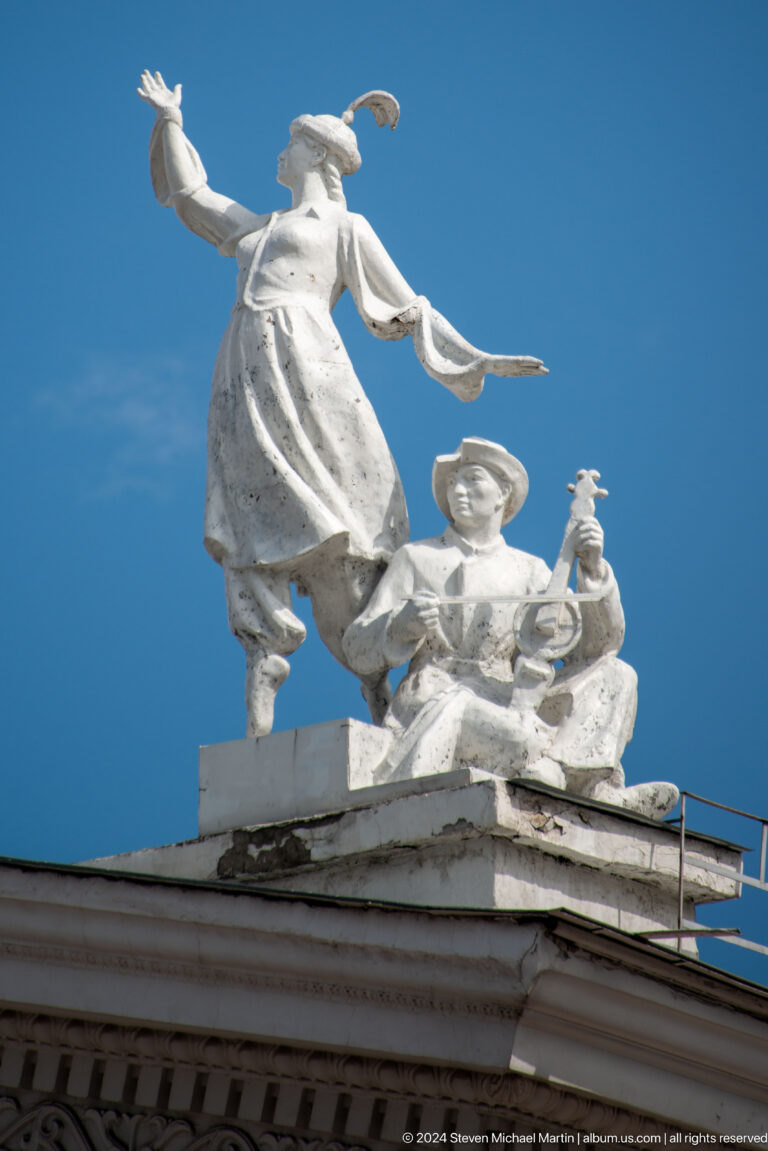 White sculpted figure holding musical instrument in Bishkek, Kyrgyzstan.