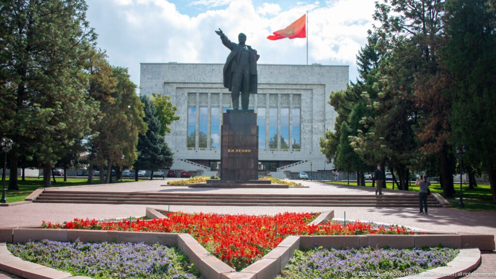 Lenin statue before government building and flowers in Bishkek, Kyrgyzstan.