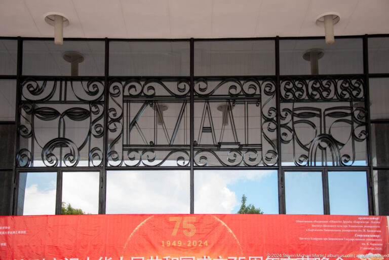 Ironwork sign with 75 anniversary banner in Bishkek, Kyrgyzstan.