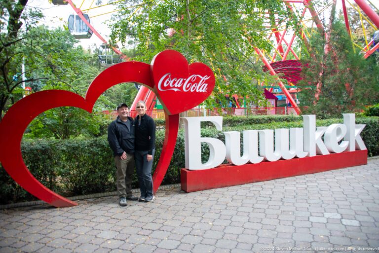 Visitor beside large Bishkek city sign in Bishkek, Kyrgyzstan.