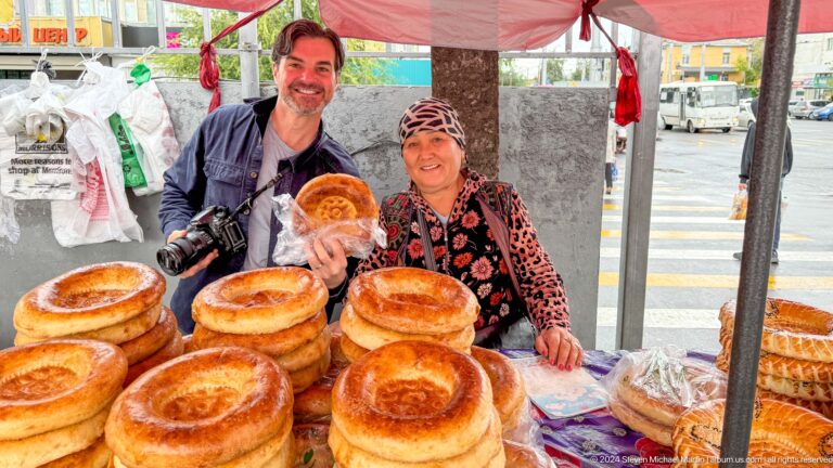 Two women selling round breads outdoors in Bishkek, Kyrgyzstan.