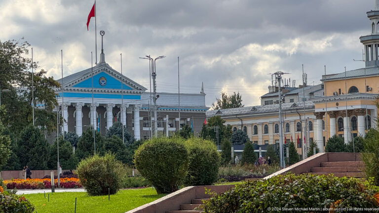 Blue-pediment government building behind garden in Bishkek, Kyrgyzstan.