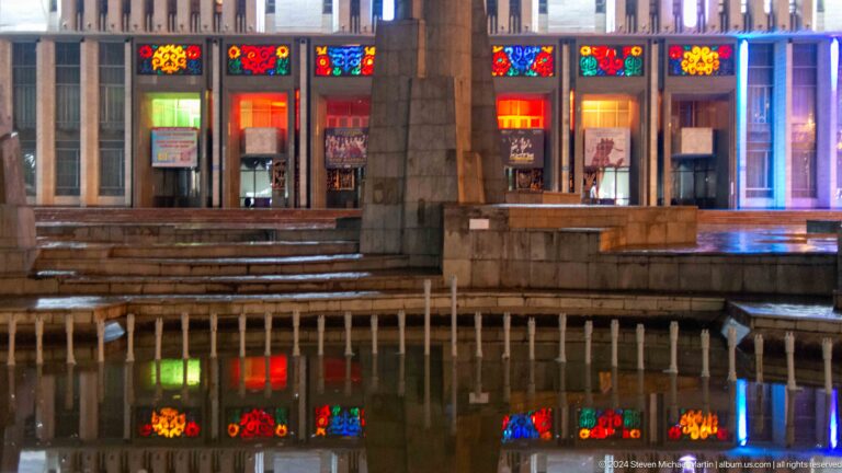 Museum entrance reflected in wet pavement in Bishkek, Kyrgyzstan.