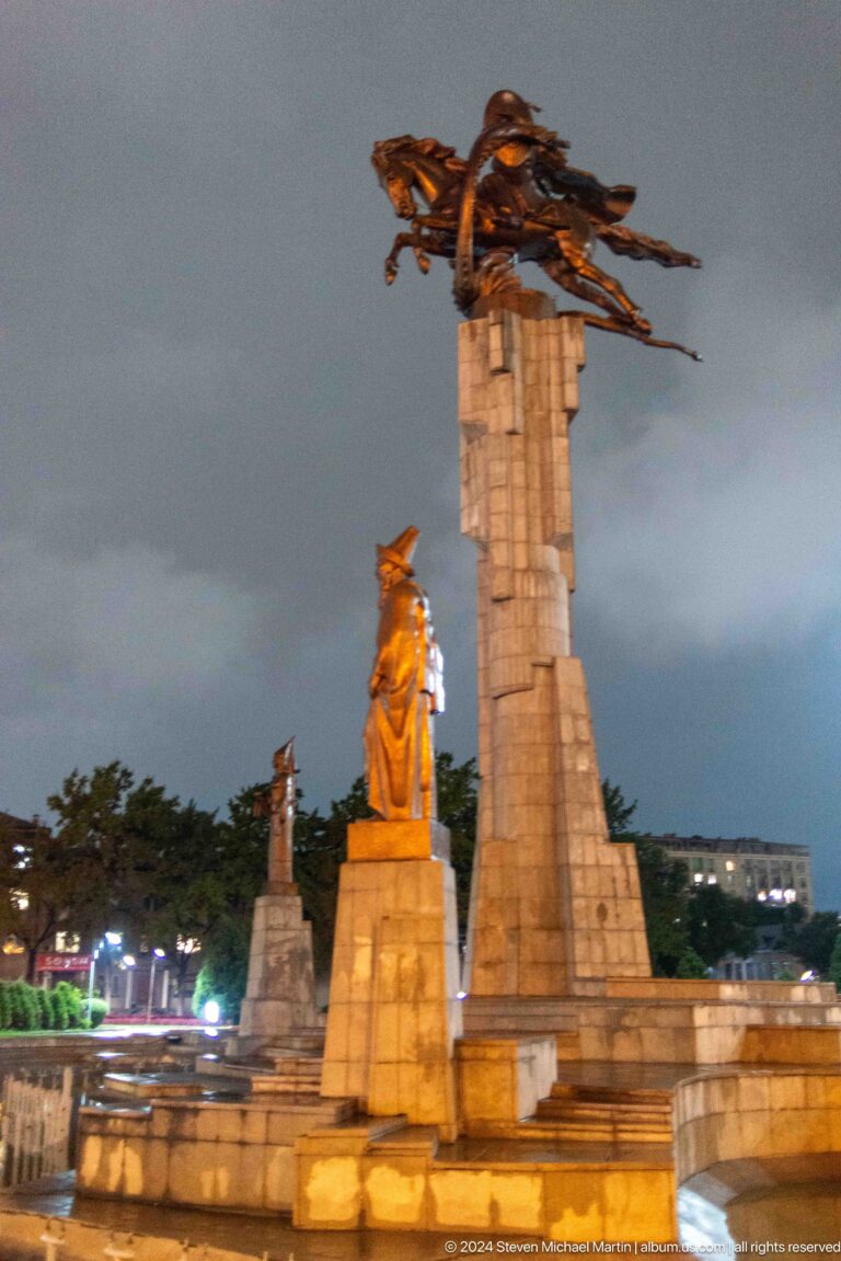 Female statue beside tall monument in Bishkek, Kyrgyzstan.