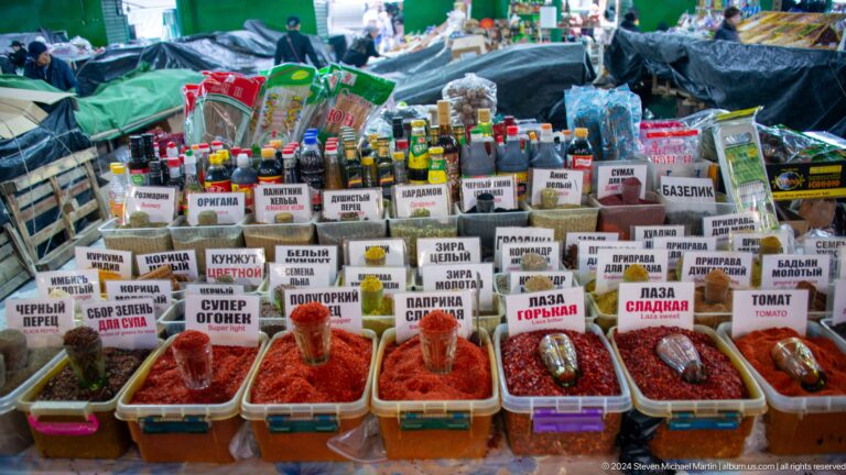 Labeled bins of colorful spices and seasonings in Bishkek, Kyrgyzstan.