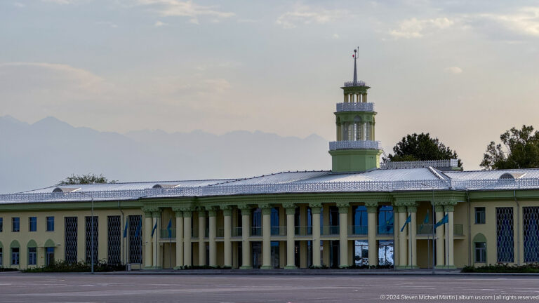 Soviet-era terminal building with small control tower in Bishkek, Kyrgyzstan.