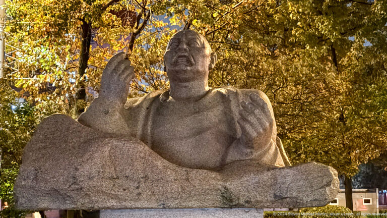 Stone sculpture of seated epic figure in Bishkek, Kyrgyzstan.
