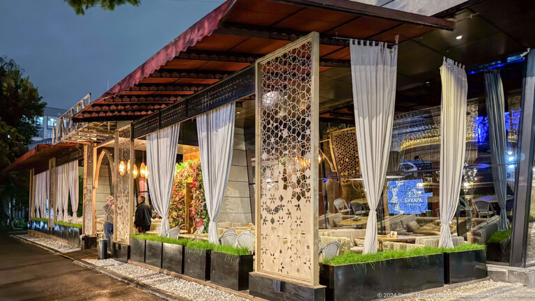Open-air restaurant pavilion with curtains in Bishkek, Kyrgyzstan.