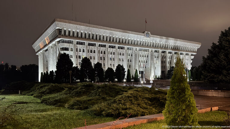 Large white government building at night in Bishkek, Kyrgyzstan.