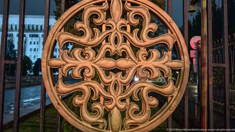 Round carved wooden ornament on textile background in Bishkek, Kyrgyzstan.