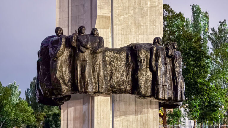 Bronze group projecting from stone monument in Bishkek, Kyrgyzstan.