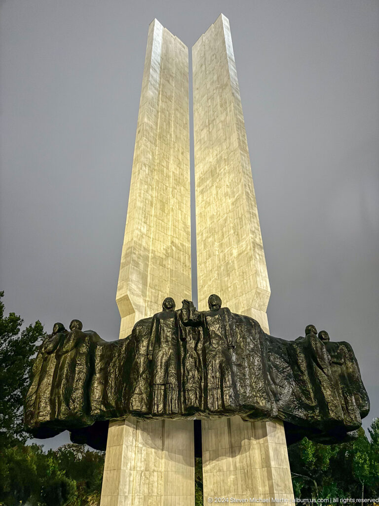 Bronze figures at base of pale obelisk in Bishkek, Kyrgyzstan.
