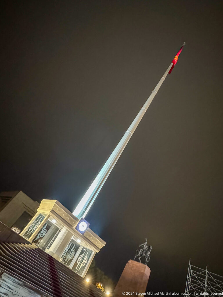 Diagonal flagpole or monument against dark sky in Bishkek, Kyrgyzstan.