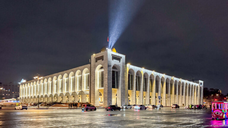 Large illuminated public building with colonnades in Bishkek, Kyrgyzstan.