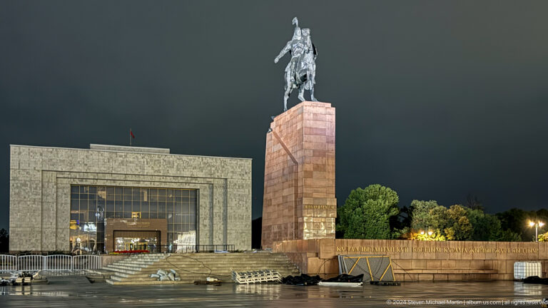 Statue on red pedestal before museum building in Bishkek, Kyrgyzstan.