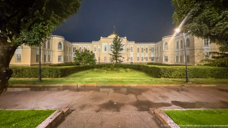 Illuminated academy-like building and lawn in Bishkek, Kyrgyzstan.