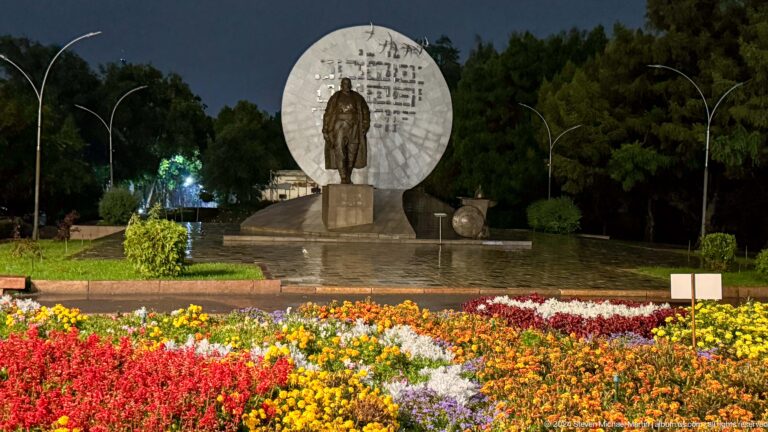 Standing figure before large circular stone disk in Bishkek, Kyrgyzstan.