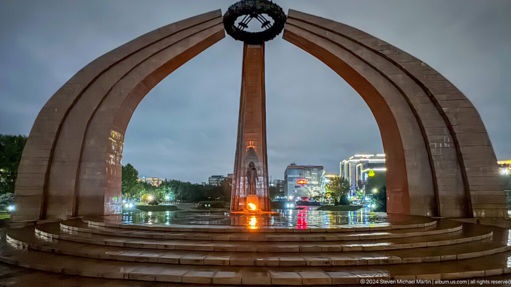 Arched Independence Monument reflected in pool in Bishkek, Kyrgyzstan.
