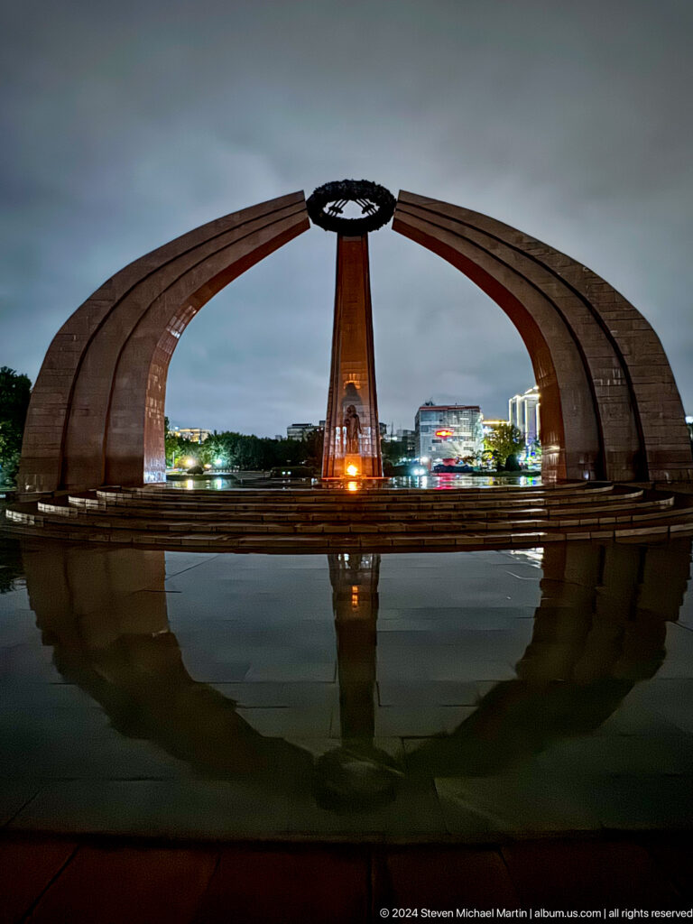 Wide Independence Monument reflected at dusk in Bishkek, Kyrgyzstan.