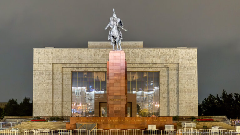 Statue and museum aligned across square in Bishkek, Kyrgyzstan.